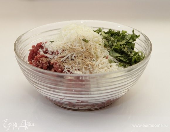 Подготовим фарш для тефтелек. Провернем телятину. Добавим 3 столовые ложки свеженатертого пармезана, несколько веточек (берем только листья) порубленного зеленого базилика.

