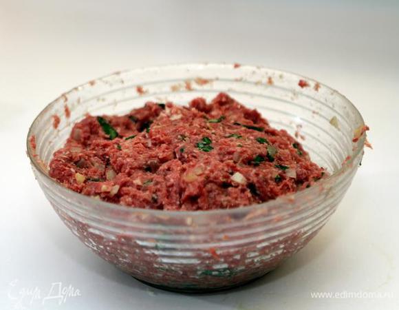 Добавим туда же пассированный лук с чесноком.
Натрем половинку мускатного ореха, добавим соль и перец. Перемешаем фарш до однородности (примерно 3 – 4 минуты). 