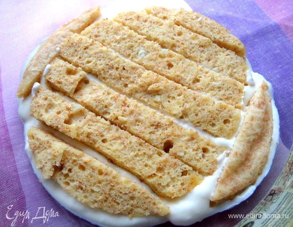 На дно формы (у меня стеклянная с диаметром дна 16 см и верха диаметром 21 см) распределяем немного крема и утопим в нём полоски бисквита.