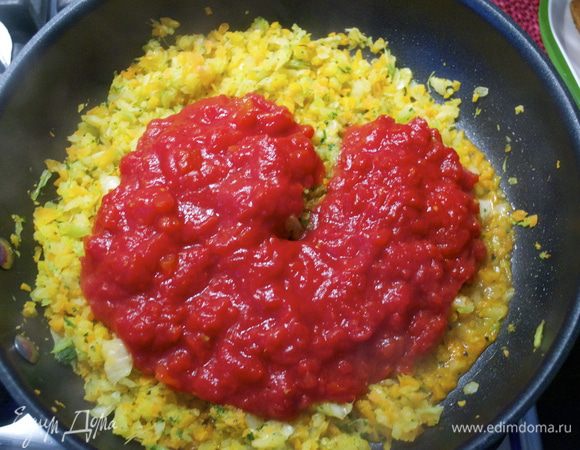Добавить предварительно размятые томаты в собственном соку. Посолить и поперчить по вкусу и готовить томатный соус около 8 минут на среднем огне, время от времени помешивая. 