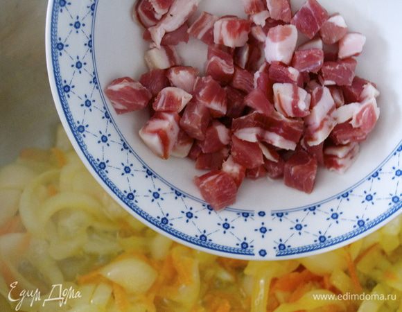 Бекон нарезать небольшими кубиками и добавить к овощам. Обжаривать еще 5-7 минут.