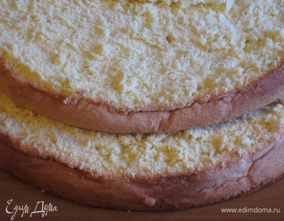 Остудить бисквит на решетке и разрезать на 2 коржа.
