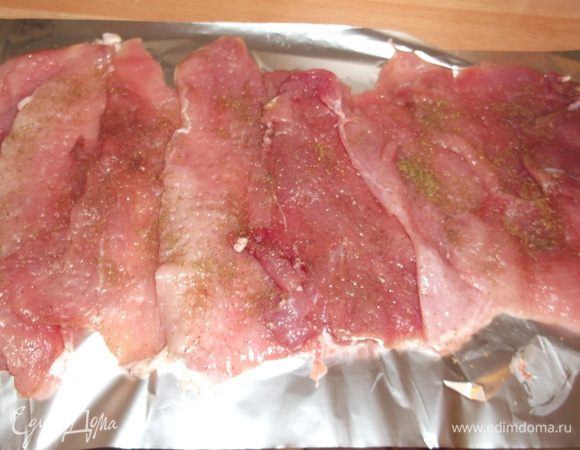 Если кусок мяса идет целиком, то распластываем его при помощи острого ножа, разрезаем не до конца,  раскрываем как книгу  и хорошенько отбиваем. У меня куплены уже нарезанные кусочки вырезки на отбивные, которые я тоже отбиваю, солю, перчу смесью перцев (можно посыпать любыми специями для мяса на ваш вкус) и укладываю внахлёст на смазанной маслом фольге. Оставляем для пропитки специями, а в это время готовим начинку.