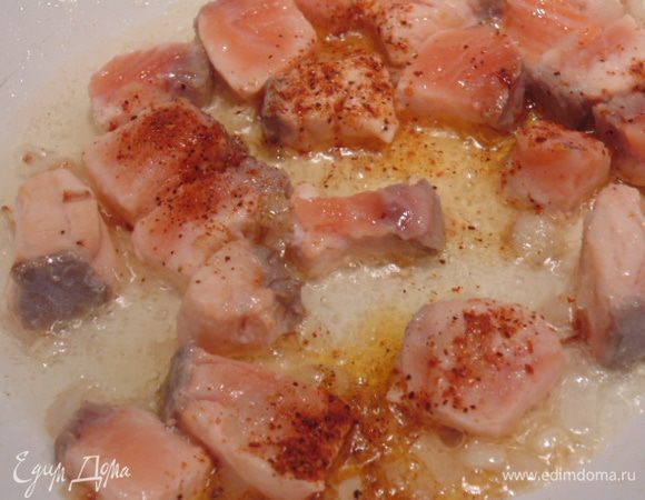 Добавить лук и обжарить его, добавить семгу, обжарить 3 минуты, посолить и поперчить.