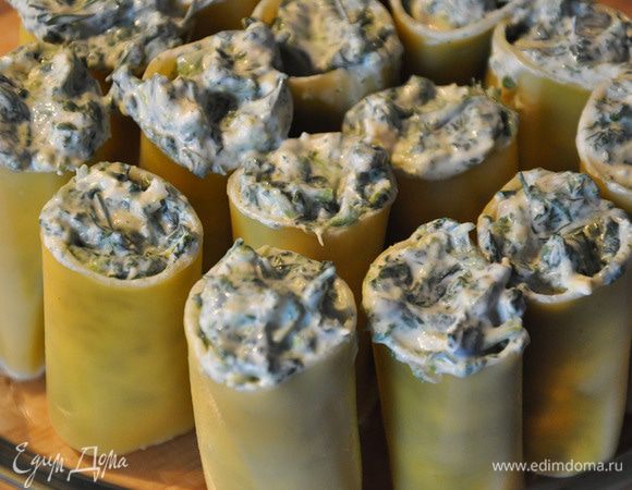 Поставить в огнеупорную посуду пасту, предварительно перерезав пополам. Заполнить начинкой с помощью чайной ложки.