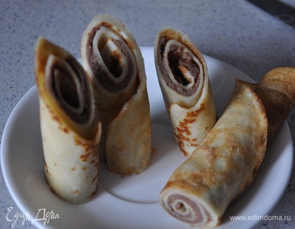 Разрежьте блины пополам и отрежьте ровно или по косой наружный край.