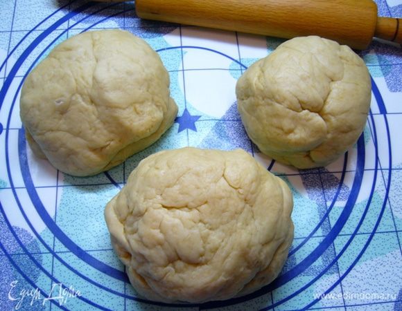 Разделить тесто на 3 части, одна должна быть меньшего размера.
Противень застелить бумагой для выпечки, кулебяку будем собирать прямо на противне.
Раскатать меньшую часть теста.
Уложить на противень.
