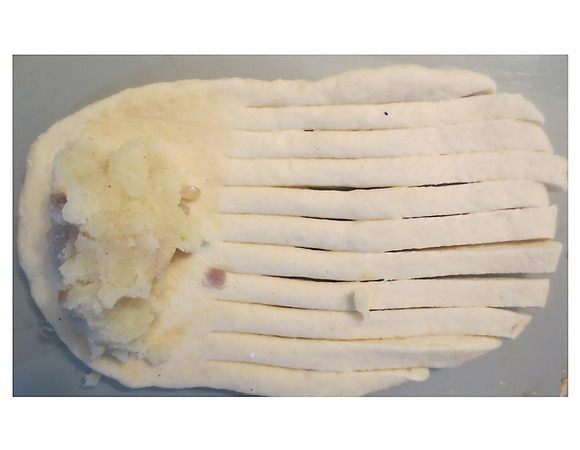 На другой конец выкладываем начинку и аккуратно заворачиваем. 
Взбиваем яичный желток, смазываем кисточкой пирожки и оставляем на 20 минут. Затем выпекаем при температуре 180 градусов до румяного цвета.