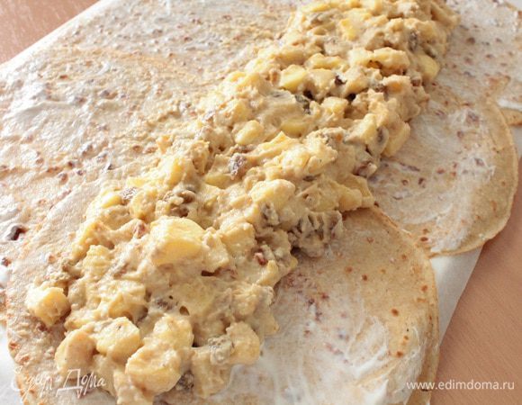 Нанести тонкий слой сметаны на каждый блинчик, приподнимая края, которые накладываются друг на друга. Затем выкладываем начинку.