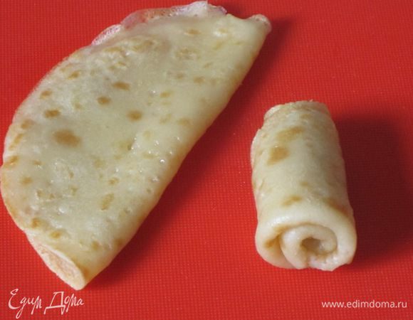 Теперь блинчики надо превратить в "розочки". Каждая "розочка" состоит из 6 блинчиков, но можно взять и 5 блинчиков. Первый блинчик свернуть пополам, а затем скрутить в рулетик.