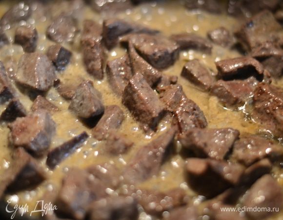 Печень отправить в сито, чтобы вытекла вся жидкость. Прожарить на разогретой сковородке с небольшим количеством растительного масла около 10 минут, затем посолить по вкусу, добавить сливки, протушить еще минут 10, добавив 1 ч.л. сахара.