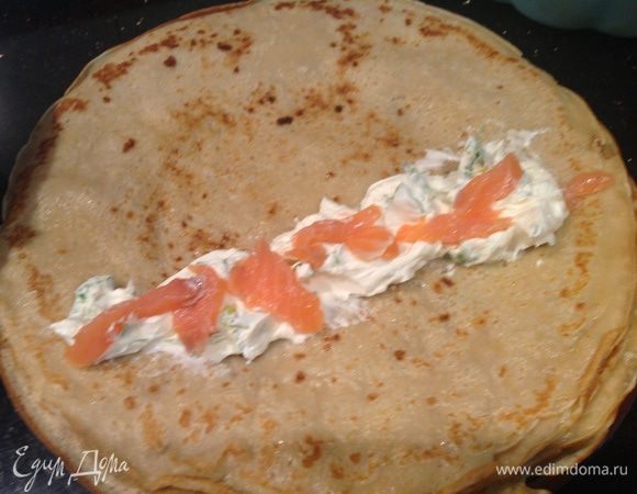 Выложите на блин начинку: сначала творожную массу, сверху рыбку. Заверните блин трубочкой.