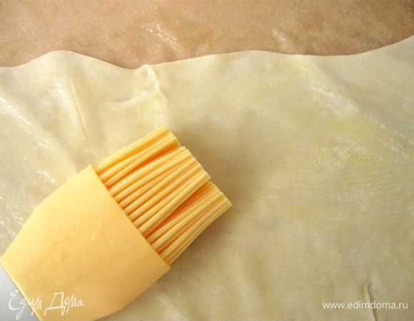 Промазать половину куска (до средней линии) сливочным маслом и сложить пополам. Так же поступить  с другим куском теста (промазать маслом и сложить пополам).  Наложить один кусок теста на другой, предварительно промазав слой соприкосновения  маслом.

