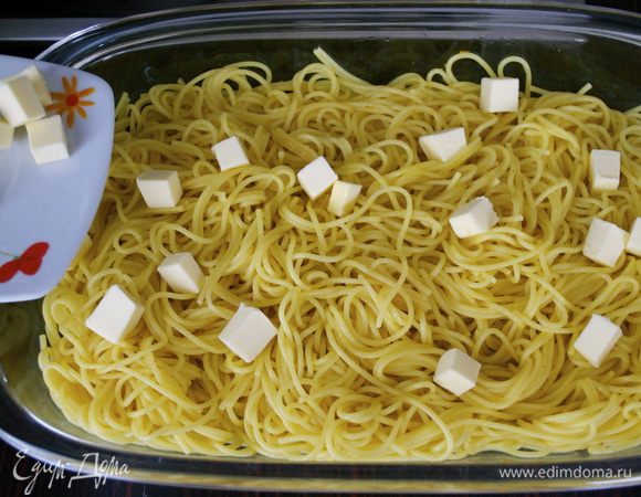 Сливочное масло порезать маленькими кубиками и, как только паста полностью остынет, добавить к спагетти и перемешать.