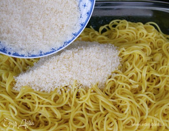 Твердый сыр мелко натереть и добавить к спагетти, снова размешать.