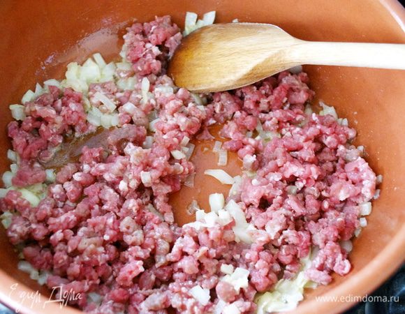 Теперь займемся приготовлением начинки для колобков. Лук мелко нарезать и положить обжариваться на сковороду с оливковым и сливочным маслом. Как  только лук станет мягче, добавить фарш. Обжарить, помешивая, минут 7. Затем влить вино и дать ему испариться.