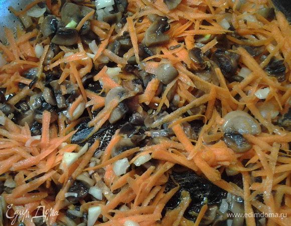 Когда из грибов выпарится жидкость добавить морковь и лук. Все обжарить.