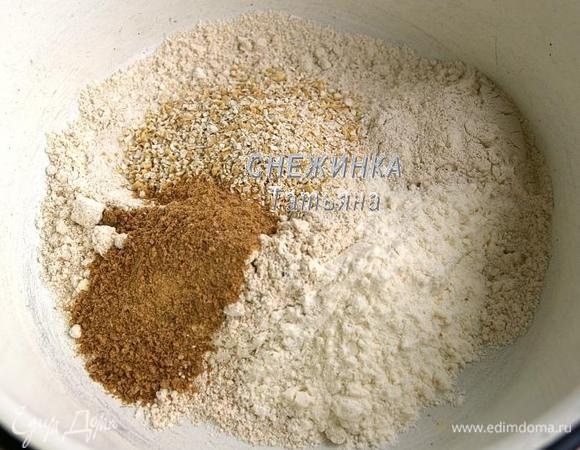 В миске смешиваем овсяную, ржаную, пшеничную муку, добавляем овсяные хлопья и измельчённые пшеничные хлопья (я измельчила при помощи ступки). Перемешиваем. Обращаю внимание, что столовые ложки у меня без всяких горок!