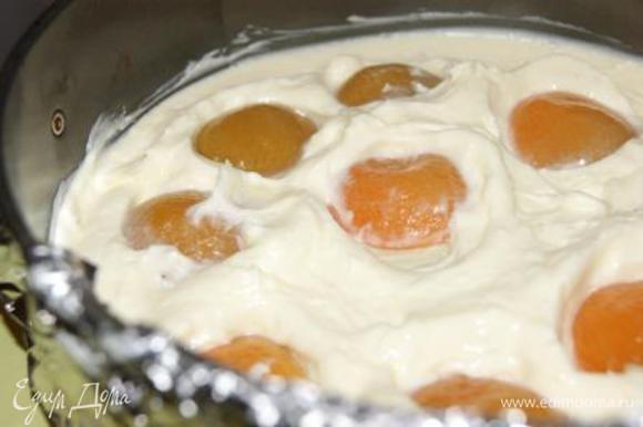 Выложить первую часть крема и половину абрикосов. Отправить в морозилку на 5-7 минут.