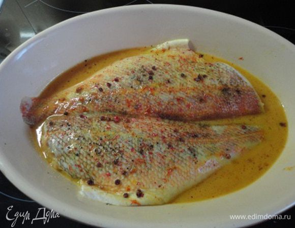 Смазать маслом противень и уложить на него филе окуня, полив сверху рыбу маринадом, посолить и поперчить.