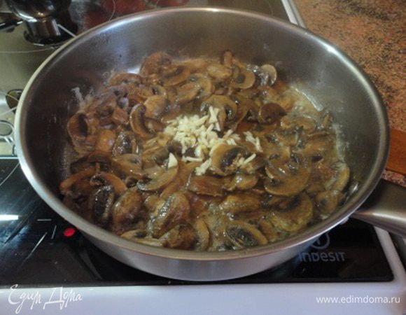 Нарезать на четвертинки грибы и обжарить на оливковом масле в течение пяти минут, добавить мелко нарубленный чеснок, посолить, поперчить и снять с огня.