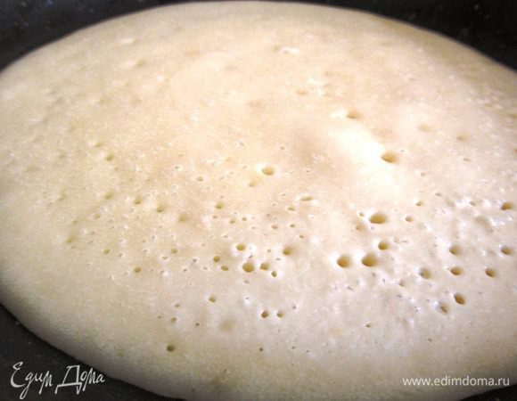 Перед приготовлением первого блинчика сковороду слегка смазать сливочным маслом. ВНИМАНИЕ, сковорода должна быть холодной. Блинчики выпекаем на небольшом огне. Помните, что после каждого блинчика сковороду нужно охладить под холодной водой. Блинчик готов, когда появилось много пузырьков, и верх теста не липнет к лопаточке.
Диаметр блинчика примерно 15-20 см. ВАЖНО! Тесто выливаем по центру сковороды, примерно половину половника и ждем пока блинчик приготовиться. Распространять тесто НЕ НУЖНО по сковороде, как мы обычно делаем с простыми блинчиками.
На водяной бане растапливаем сливочное мало с медом и обильно поливаем блинчики.