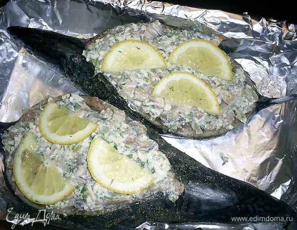 Полученной начинкой фаршируем рыбку, половинки кусочков лимона выкладываем сверху на начинку. Форму для запекания выстилаем фольгой и выкладываем рыбку спинкой вверх.