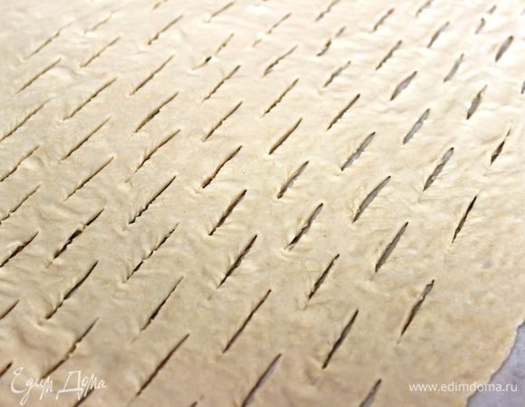 Оставшуюся часть теста немного раскатать, сделать острым ножом параллельные надрезы в шахматном порядке (каждый длиной по 2 см.).