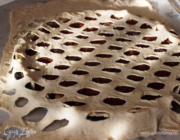 Уложить второй пласт теста на ягодную начинку, немного растянув его, чтобы надрезы расширились.