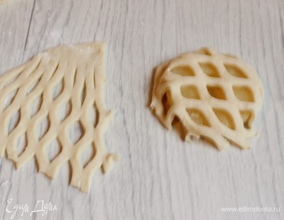 С остатков теста делаем решетку. Можно раскатать пласт и вырезать потом или сразу делать маленькую лепешку. И пройдемся специальным валиком. Накладываем поверх ананасов и подгибаем, прижимаем снизу.