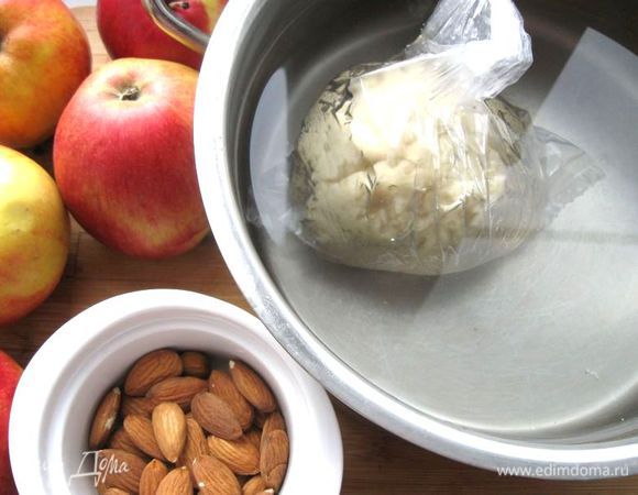 Положить тесто в  полиэтиленовый  пакет, завязать для герметичности и опустить  в теплую воду (примерно 40 градусов) на 10 мин. Яблоки почистить, разрезать на четвертинки, вырезать семенную часть, нарезать дольками средней толщины. Выдавить лимонный сок, положить сахар, натертую на мелкой терке цедру лимона. Миндаль поместить на 5 минут в кипяток. Слить воду, очистить от шелухи, измельчить, смешать с яблоками. Оставить полежать начинку минут 5. Затем поместить яблоки на сито, чтобы стек сок. В начинку положить 10 г муки. Перемешать.