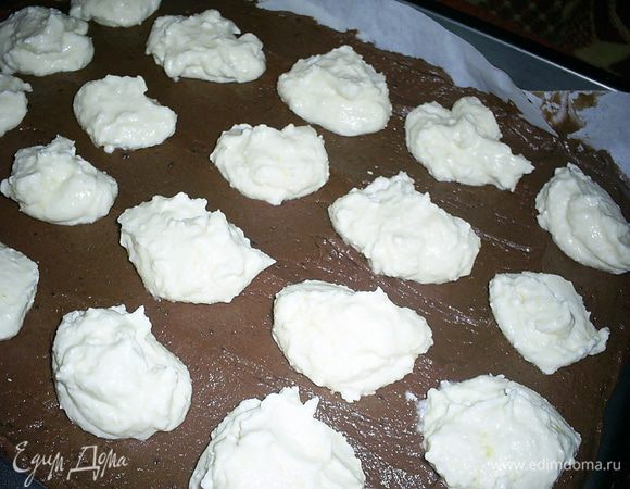 Тесто равномерно распределяем по противню 35*25 см, застеленному бумагой для выпечки. Сверху ложкой выкладываем комочками творожную начинку (примерно по неполной столовой ложке).