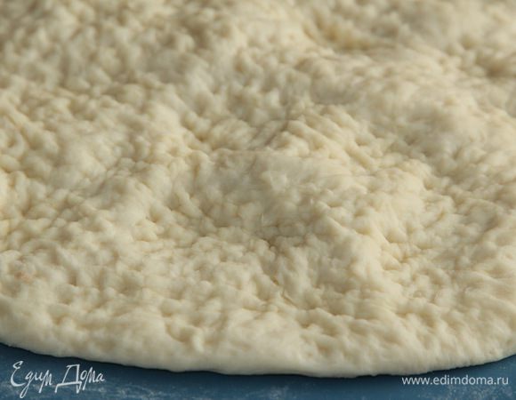 Делаем небольшой подпыл и раскатываем пласт толщиной 2-2,5 см. Затем, у кого есть докер, выкалывают пузыри им, а я взяла молоточек для отбивных и рифленой стороной прошлась по всему пласту, выбивая воздух из пузырей. Сначала с одной стороны, а затем с другой.