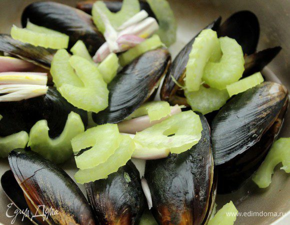Мидии хорошо промыть при помощи щетки. Сложить в сотейник, налить немного воды и поставить на 2 минуты на сильный огонь. Нераскрывшиеся мидии выкинуть. Добавить лук и сельдерей и готовить под крышкой еще 3 минуты.