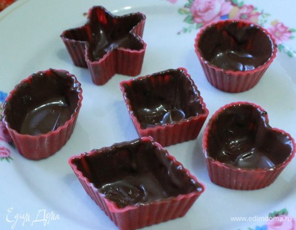 Растопить горький и молочный шоколад на водяной бане. Силиконовые формочки смазать слегка растительным маслом (главное чтобы масло было без запаха). С помощью плоской кулинарной кисточки (хотя я прекрасно справилась с этой задачей с  помощью кофейной ложечки) нанести шоколад по бокам и на дно формочки. Отправить в холодильник на 10 минут. Затем опять смазать стенки и дно формочки шоколадом. И снова в холодильник на 5 минут.