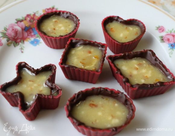 Затем маленькой ложечкой или с помощью кондитерского мешка, выложить апельсиновую начинку, но не заполнять до краев (помните, что нужно еще сделать донышко конфеты). 