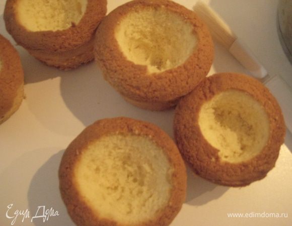 У маффинов вырезать серединку, один маффин и вырезанное тесто порезать кубиками. Смешать ананасовый сок с ромом, пропитать маффины внутри.