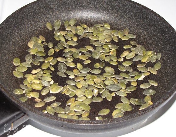 На сухой сковороде обжарьте тыквенные семечки до золотистого цвета.