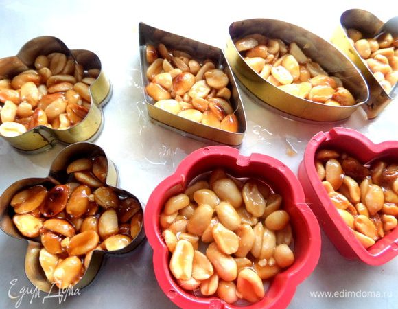 И раскладываем по формочкам толщиной не более 2 см...Вот тут не всё так просто))) За ложкой тянутся карамельные нити-это раз,орешки ни в какую не хотят сниматься с ложки-это два,прижимая орешки пальцем,мы рискуем обжечь их-это три))) Но я справилась!!! Правда пришлось держать массу на мизерном огне,чтобы карамель раньше времени не схватилась (если это случилось-ничего страшного,на огне она снова распустится).