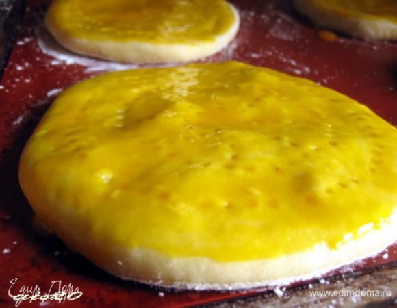 Затем кладём лепёшку швом вниз и раскатываем её толщиной в 1,5 см. Укладываем швом вниз на  смазанный маслом противень. Наносим вилкой узоры, чуть прокалывая лепешку. Смазываем желтком.
