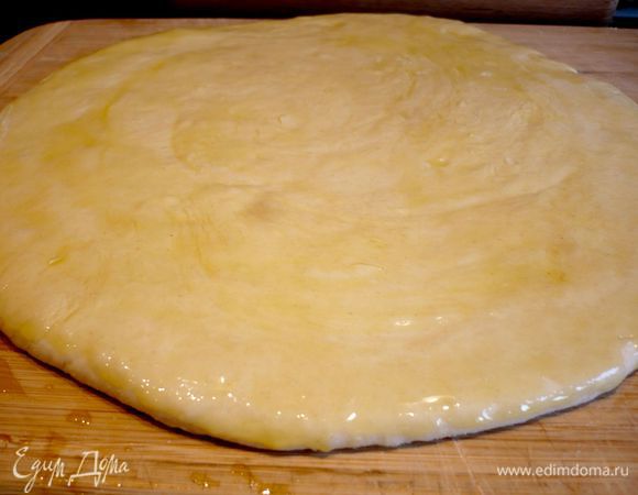 Раскатываем тесто в лепешку на слегка присыпанной мукой поверхности. Смазываем растопленным маргарином (признаюсь, что у меня его не было, поэтому смазала 1 ст.л. оливкового масла, но лучше, конечно, взять маргарин или сливочное масло). Сворачиваем лепешку в рулет, заворачиваем в пленку и убираем в холод на полчаса.
