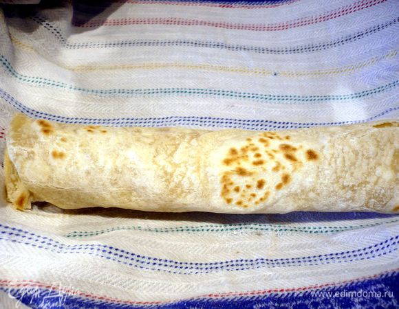 Обжариваем лепешку по паре минут с каждой стороны на смазанной оливковым маслом и раскаленной сковороде. Сразу укладываем готовую лепешку на влажное полотенце и сворачиваем в рулет, прикрываем полотенцем и проделываем то же самое с остальными частями теста.