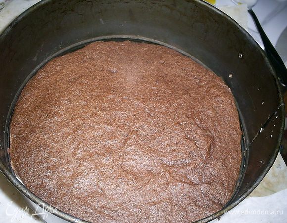 Приступаем к сборке. На блюдо кладем один корж,  заключаем его в кольцо разъемной формы. Чтоб блюдо не испачкалось, под корж можно подложить бумагу для выпечки, нарезанную полосками.