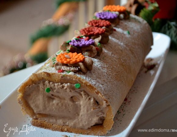 Развернуть рулет, выложить начинку и распределить по всей поверхности, края оставим без начинки, чтоб она не вытекала. Завернем обратно в рулет. Сверху сахарную пудру. Я украсила оставшимся кремом, выложила в кондитерский мешок и распределила по центру, сверху украсила готовыми съедобными цветами из мастики.