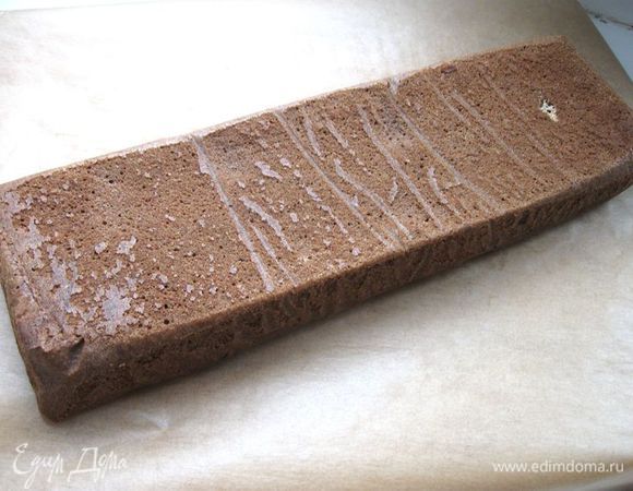 Полученную массу равномерно разложить слоем в  2 – 2,5 см  в прямоугольную форму, покрытую бумагой для выпечки. Испечь в духовке при температуре 200 - 210 градусов в течение примерно  30 - 35 минут (готовность проверять зубочисткой).  Готовый пласт через некоторое время после выпечки перевернуть на доску, покрытую бумагой для выпечки, снять верхний слой бумаги и дать коржу остыть.
