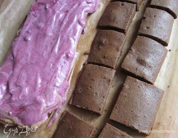 Корж разрезать  вдоль на две  части, нижнюю часть покрыть  слоем смеси сливок с шоколадом ( более светлой), на него равномерно положить джем, смешанный с 30 г взбитых сливок. Другую половину коржа разрезать на прямоугольники небольшого размера.

