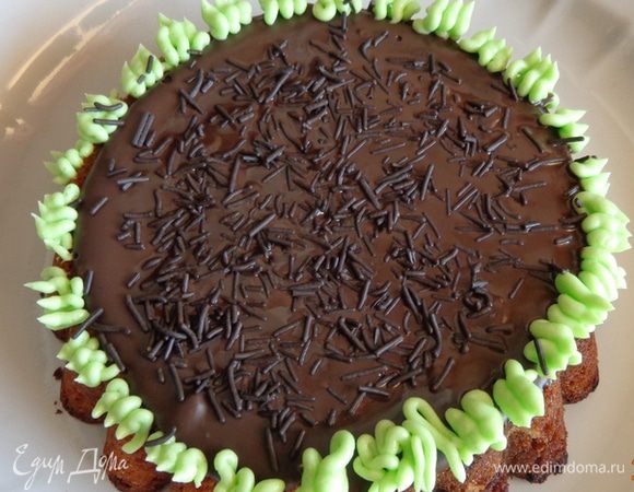 Приготовить тесто для кекса: масло комнатной температуры взбить с сахаром, по одному ввести яйца, продолжая взбивать, затем добавить муку с разрыхлителем и изюм с орехами. Перемешать. Выпекать в форме для кексов Д15 см и маффинов (у меня получилось 4 штуки) при 180 градусах минут 25-30. остудить. Срезать выпуклую верхушку. Залить верх растопленным шоколадом и украсить "травой" из масляного крема. Охладить. Так же украсить и маффины.