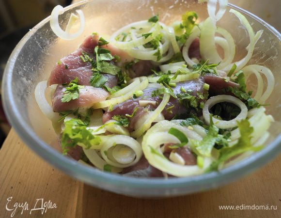 Не жирную свинину промыть, нарезать на небольшие кусочки (примерно, как для шашлыка), сложить в миску. Мясо посолить, поперчить, заправить растительным маслом и хорошо перемешать. Добавить измельченный чеснок, рубленную зелень петрушки, репчатый лук нарезанный кольцами. Выжать сок из лимона и заправить им мясо, хорошо перемешать и оставить мариноваться на 3 часа, можно дольше. Периодически мясо перемешивать. 