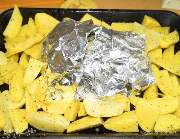 Завернуть мясо в фольгу. Вокруг выложить картофель и поставить запекаться в духовку, разогретую до 180 градусов. Готовить примерно 1 час, затем раскрыть фольгу (для того чтобы мясо зарумянилось) и запекать еще минут 15.