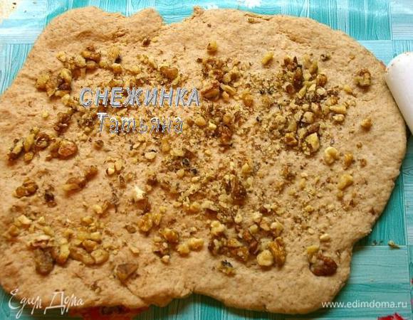 Распластываем тесто руками, посыпаем орехами.